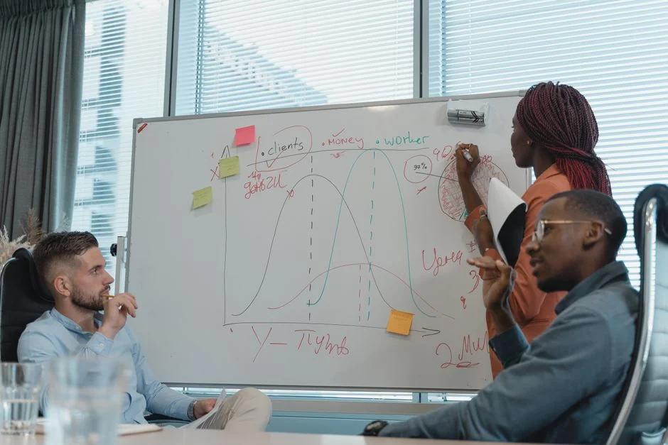 Vue de dessus d’une équipe commerciale analysant des graphiques et des données sur papier pour la planification stratégique.